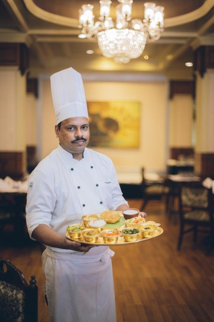 Taj Ganges Варанаси Екстериор снимка A chef with a selection of Indian snacks